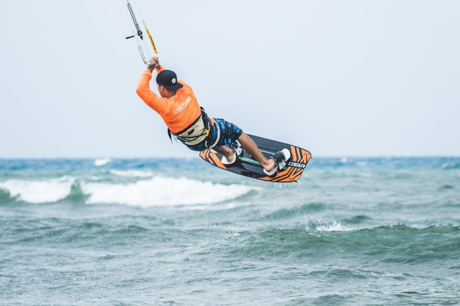 Action-packed kiteboarding scene with an athlete performing tricks over the ocean waves.