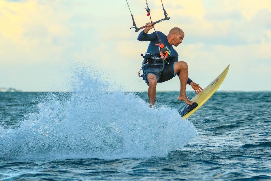 Man kiteboarding on the ocean with waves and splashes, capturing action and excitement.