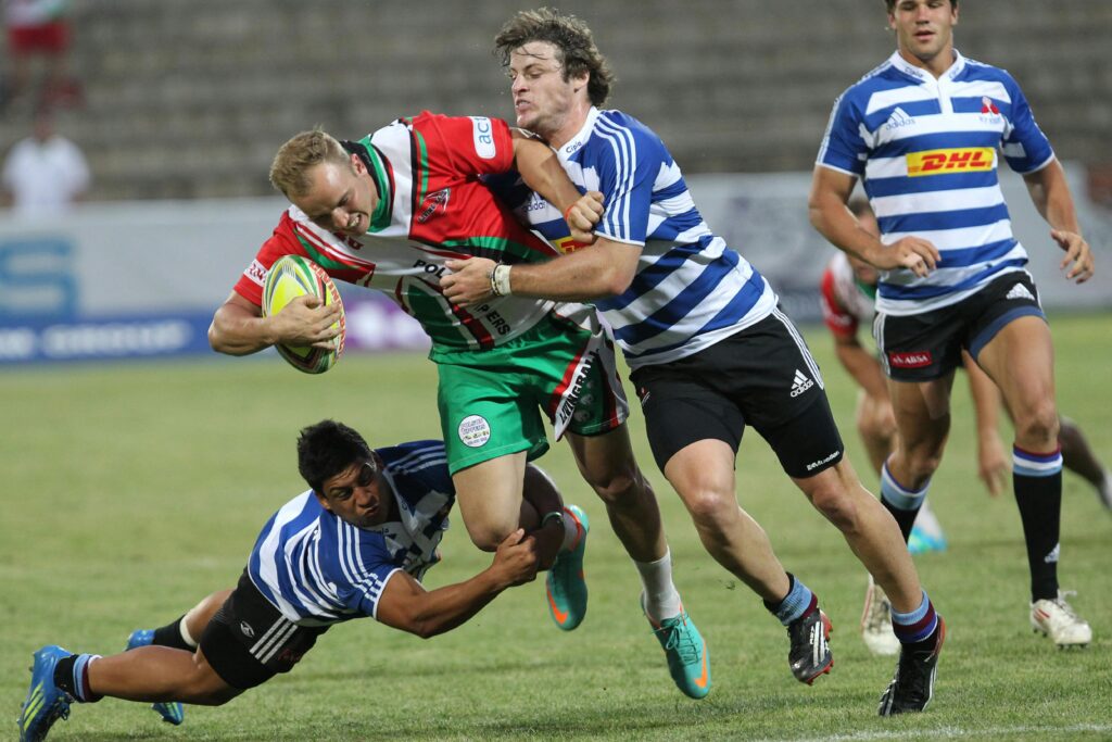 Dynamic action shot of rugby players in a fierce tackle during a lively outdoor game.