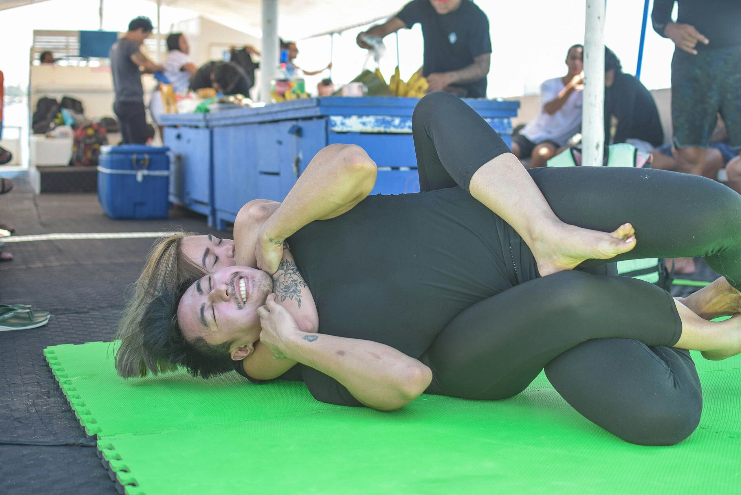woman in black tank top lying on green floor